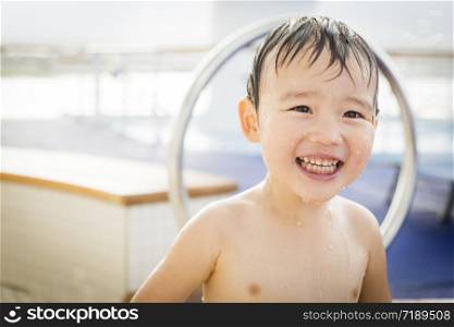 Mixed Race Boy Having Fun at the Water Park with Large Rubber Duck in the Background.