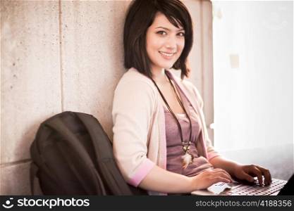 Mixed race college student working on laptop at campus
