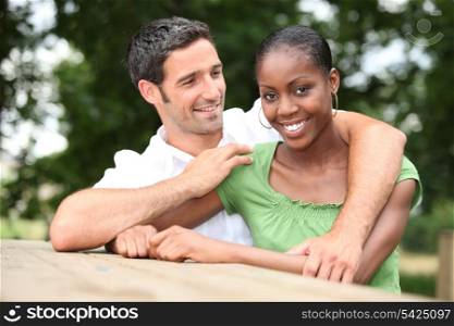 Mixed race couple cuddling in the countryside