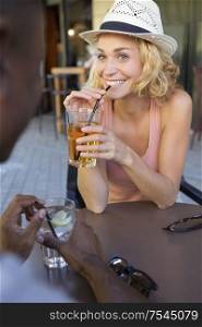 mixed race couple having a drink on bar terrace