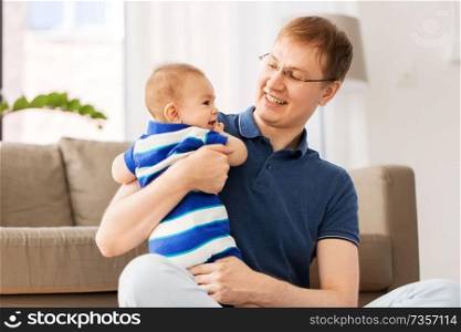 mixed-race family, fatherhood and childhood concept - happy father with baby son at home. happy father with baby son at home