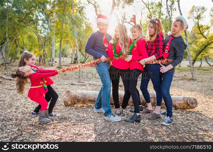 Mixed Race Family Portrait With Children Tying Up Group With Tinsel Rope.