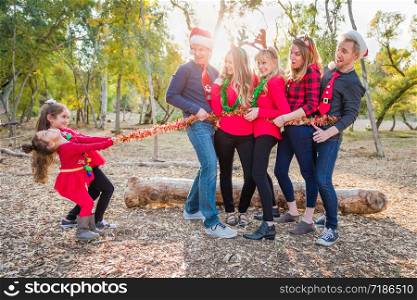 Mixed Race Family Portrait With Children Tying Up Group With Tinsel Rope.