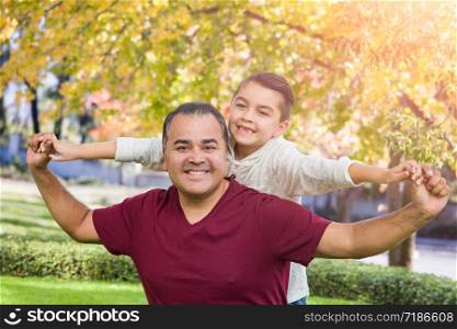 Mixed Race Hispanic and Caucasian Son and Father Having Fun At The Park.