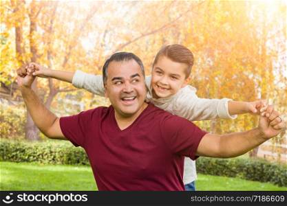 Mixed Race Hispanic and Caucasian Son and Father Having Fun At The Park.