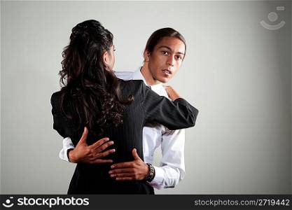 Mixed race professional man embracing Hispanic woman