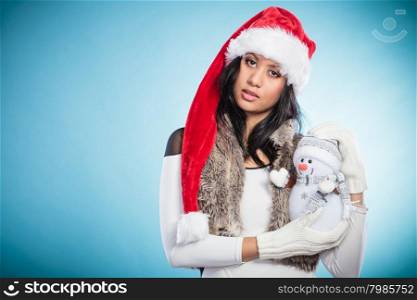 Mixed race woman in santa hat with little snowman.. Woman in santa claus hat holding little snowman. Mixed race african girl. Christmas.