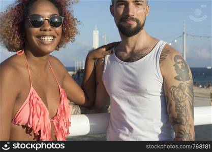Mixed raced couple on sunny beach in summer vacation