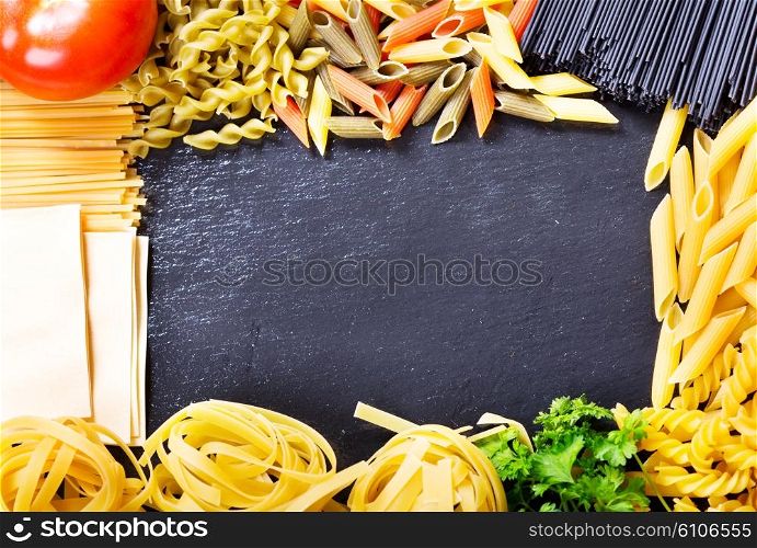 mixed raw pasta on dark background