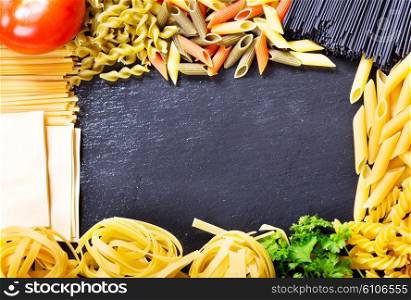 mixed raw pasta on dark background