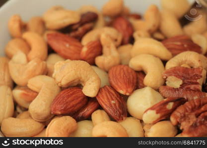 Mixed roasted nuts as an appetizer: cashew, peanuts and almonds