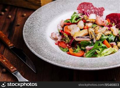 mixed seafood salad on plate. Fresh seafood cocktail in plate on wood background