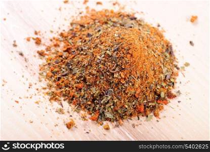 Mixed spicery heap on the wooden table in kitchen