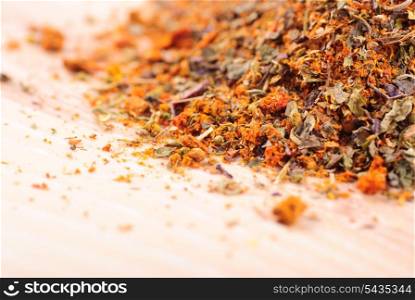 Mixed spicery heap on the wooden table in kitchen