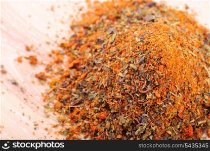 Mixed spicery heap on the wooden table in kitchen. Selective focus