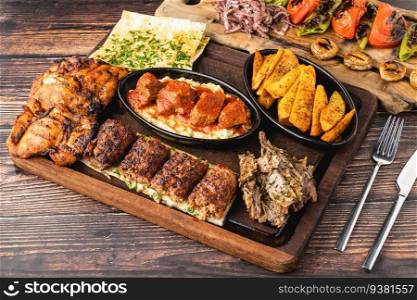 Mixed Turkish grill consisting of adana kebab, grilled chicken and lamb tandoori on wooden table