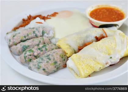mixed vietnamese rice noodle rolls with a filling of pork sliced , meat ball , vegetable and egg , fried onion , served with spicy sauce