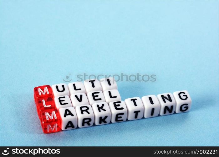 MLM Multi Level Marketing written on cubes on blue background