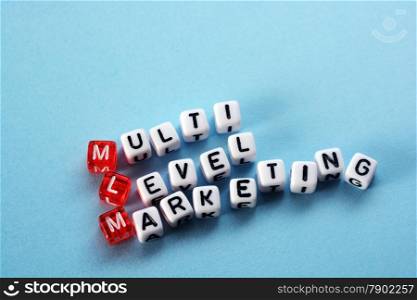 MLM Multi Level Marketing written on cubes on blue background