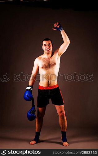 mma fighter with hands up on gray background