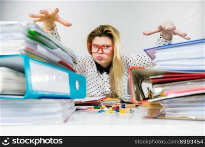 Mobbing at work, bad job relations concept. Angry mad bossy businesswoman being furious sitting working at desk full off documents in binders.. Angry mad bossy businesswoman being furious