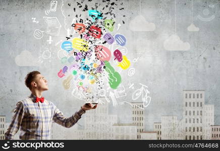 Mobile calls. Young man with mobile phone and colorful chat icons