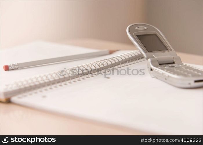 Mobile phone and notepad on a desk