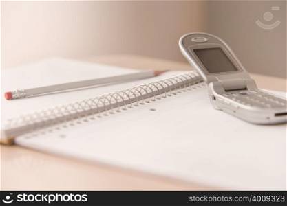 Mobile phone and notepad on a desk