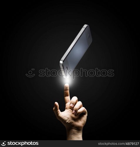 Mobile phone. Human hand pointing at mobile phone with finger