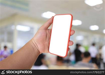 Mobile phone in hand with blank screen on hospital background and have clipping paths for your design.