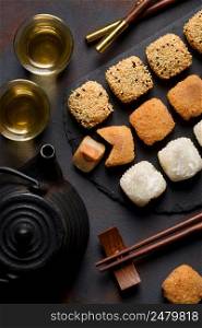 Mochi assortment with chopticks and tea traditional japanese rice dessert top view