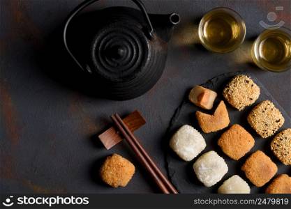 Mochi assortment with wooden chopticks and tea traditional japanese rice dessert flat lay top view