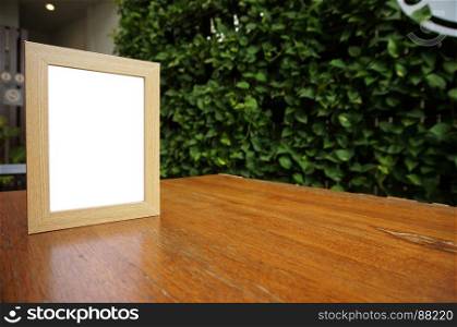 Mock up Blank white frame standing on wood table in Bar restaurant cafe. space for text. product display montage