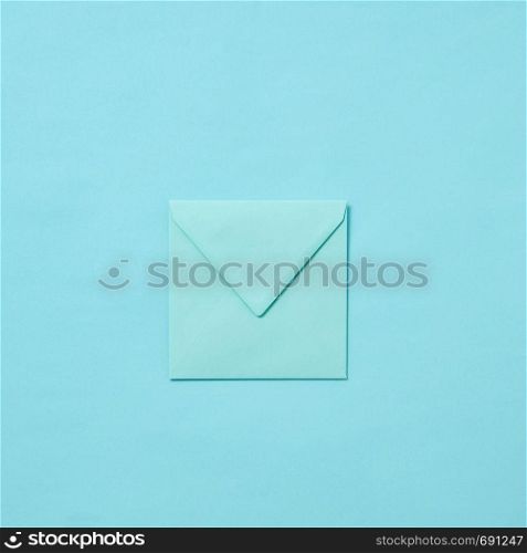 Mock up handmade envelope for greeting card or love letter on a pastel blue background with copy space. Top view.. Blank craft envelope, mock-up on a pastel background.