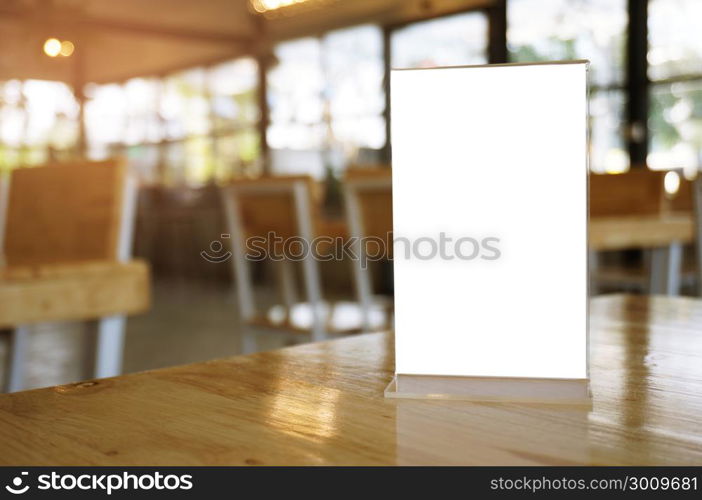 Mock up Menu frame standing on wood table in Bar restaurant cafe. space for text.