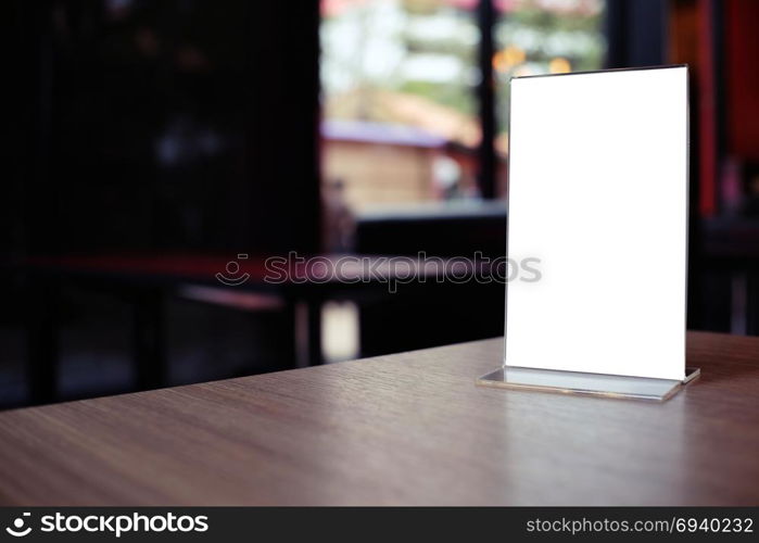 Mock up Menu frame standing on wood table in Bar restaurant cafe. space for text.