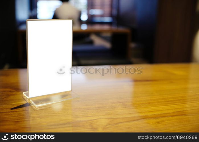 Mock up Menu frame standing on wood table in Bar restaurant cafe. space for text