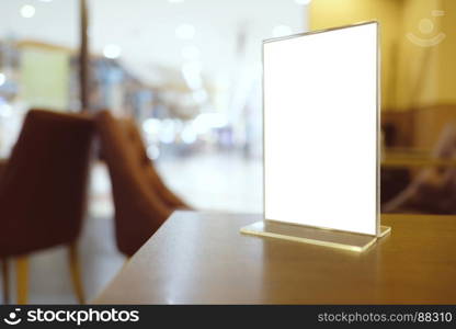 Mock up Menu frame standing on wood table in Bar restaurant cafe. space for text