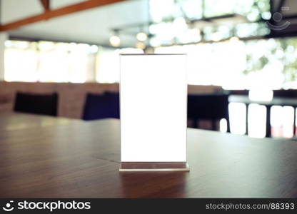 Mock up Menu frame standing on wood table in Bar restaurant cafe. space for text