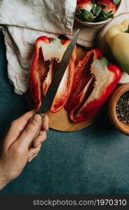 Mock up of a cooking table with a pepper cut in half a knife with a hand and some condiments