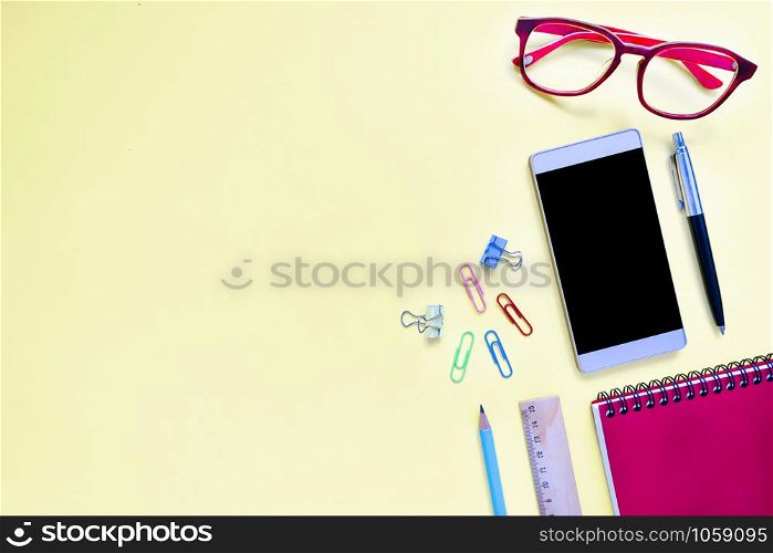 Mock up smart-phone and office equipment or accessories on colorful background with copy space, Top view
