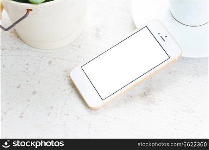 Mock up styled flat lay white hight key scene with white phone, copy space on blank screen. Mock up with white phone