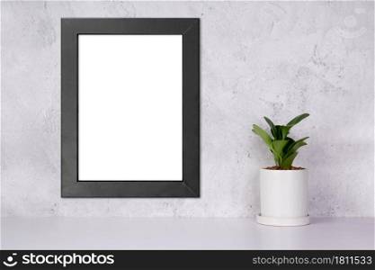 Mockup black frame vertical on the wall and plants in pot on table top at home, mock up poster for presentation on desk, your design for gallery photo and picture, border template for advertising.