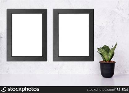 Mockup black frame vertical on the wall and plants in pot on table top at home, mock up poster for presentation on desk, your design for gallery photo and picture, border template for advertising.