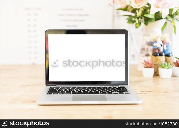 Mockup image of laptop with blank white screen on wooden table of In the coffee shop.