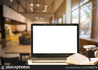 Mockup image of laptop with blank white screen with camera,notebook,coffee cup on wooden table of In the coffee shop background.