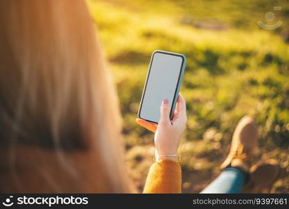 Mockup of a woman with her phone at sunset