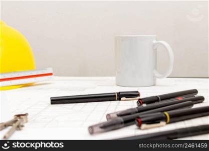 Mockup of architectural concept, Drawing tool and coffee on drawing of blueprint with safety helmet.