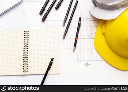 Mockup of architectural concept, Drawing tools and safety helmet on engineer drawing of blueprint.