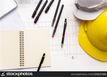 Mockup of architectural concept, Drawing tools and safety helmet on engineer drawing of blueprint.